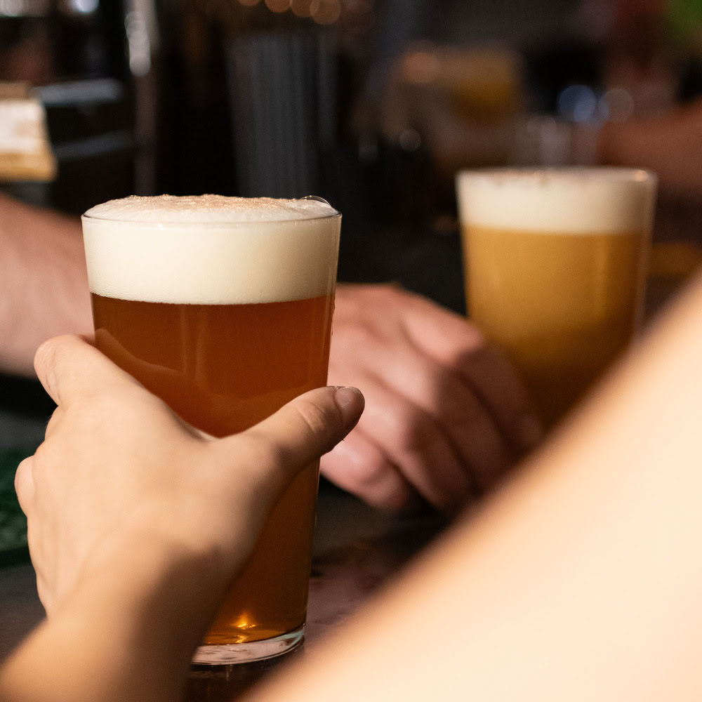 Two pints of craft beer clinking